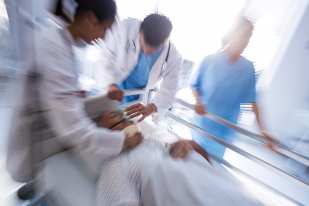 Team of doctors putting oxygen mask on a male senior patient face in the hospital